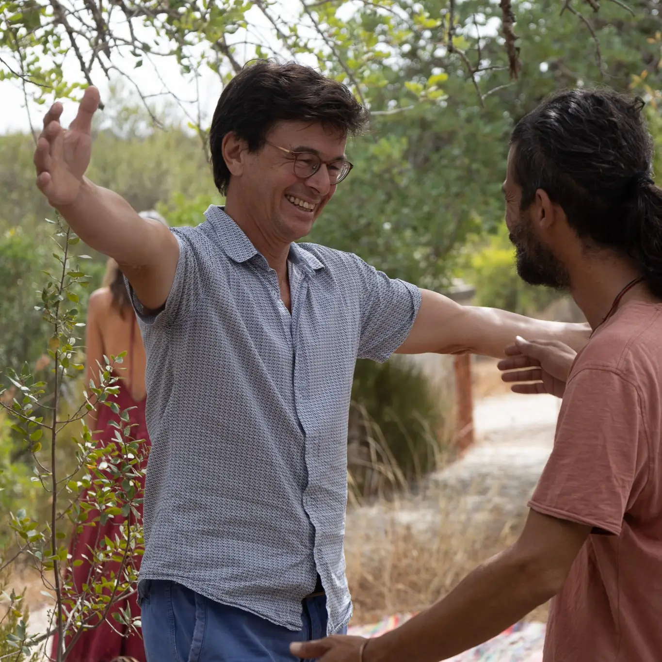 Two participants greeting each other warmly outdoors, image 6 of 13