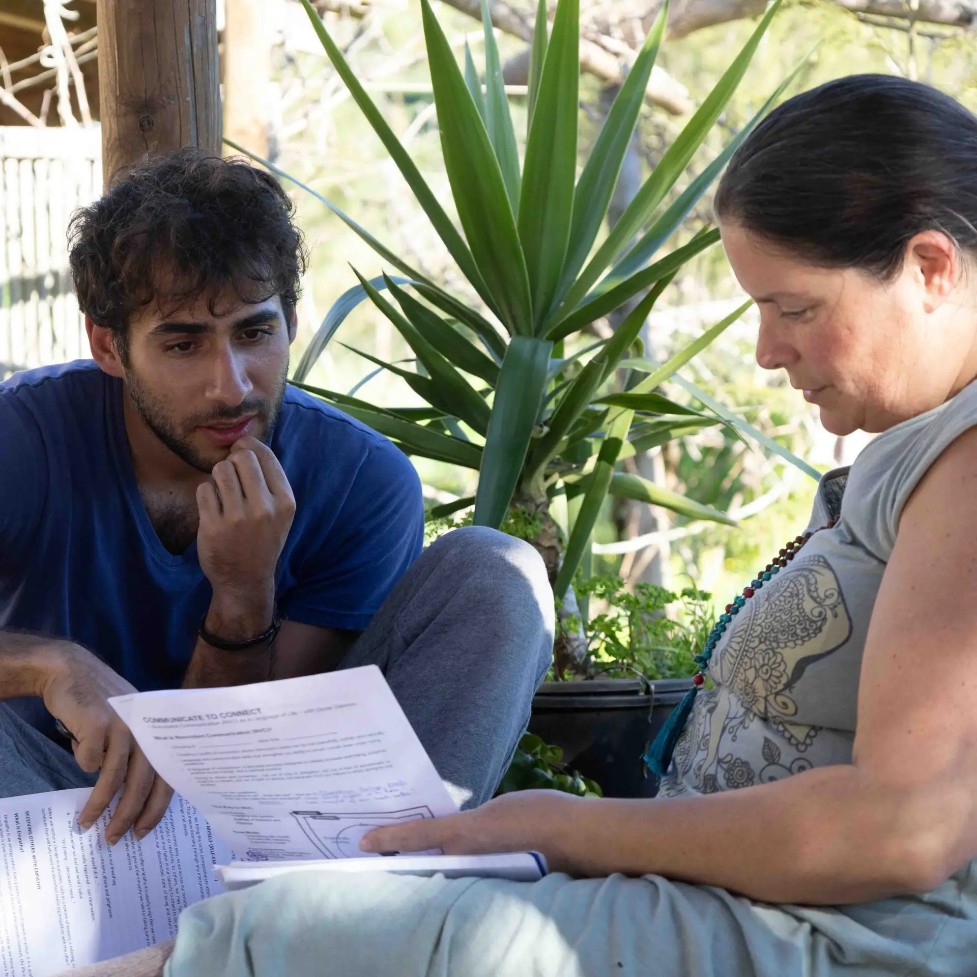 Two participants reviewing training notes together outdoors, image 5 of 13